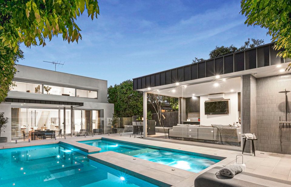 Pool, spa and pavilion at evening with the house beyond