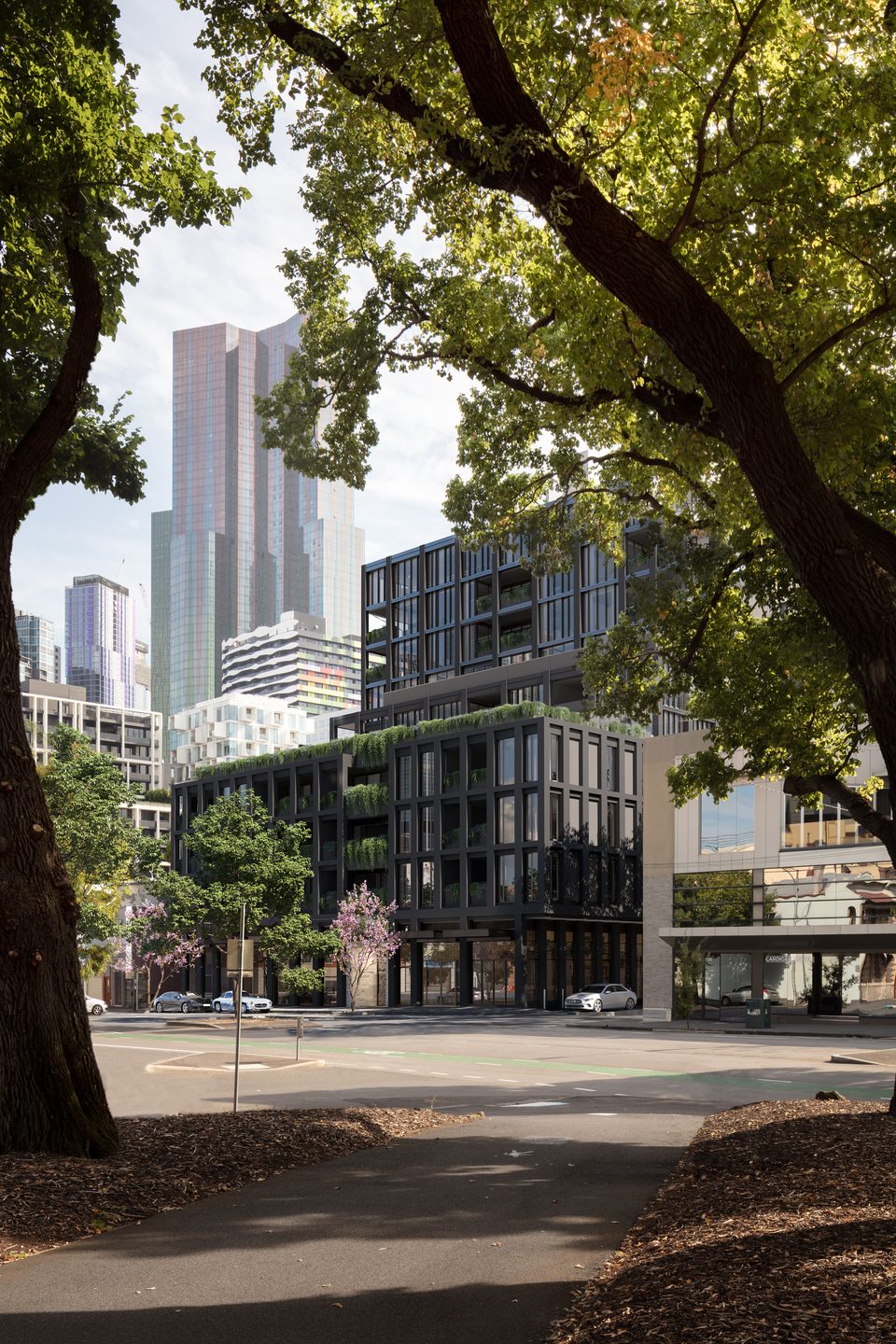 Concept render of the building seen from the park opposite, framed by mature trees with city towers behind