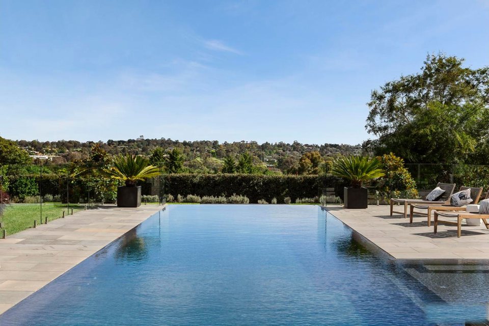 Infinity-edge pool with a view over the valley treetops